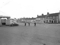 Market square Ballinrobe , March 1972.. - Lyons0016912.jpg  Roving camera in Ballinrobe. Market square Ballinrobe showing the weigh bridge and three young pupils crossing the street.  March 1972. : 19720314 Market Square Ballinrobe.tif, Ballinrobe, Lyons collection