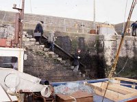 Inishbofin: Skipper Paddy Holleran carrying Dr Mc Loughlin's bag to board the ferry. - Lyons0009310.jpg  Inishbofin: Skipper Paddy Holleran carrying Dr Mc Loughlin's bag to board the ferry. : 19880217 Inishbofin 7.tif, Farmers Journal, Inis Bofin, Lyons collection