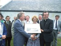 Inishturk: switching on of electricity supply. - Lyons0008942.jpg  Charles Haughey receiving a photo of Inishturk harbour taken by Liam Lyons from Fr Denis Carney. Centre Fionnuala Heaney teacher. In the background is Patrick Durcan, Mayo County Council; Sean Smith County Development Officer; Mark Killilea; Michael O' Malley County Manager and Michael O' Toole, Inishturk. (Neg 3) : 19870704 Inishturk 9.tif, Inish Turk, Lyons collection