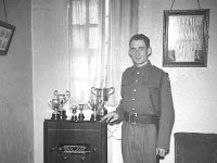 Tiny Kelly with FCA trophies, Westport, 1961. . - Lyons0013825.jpg  Tiny Kelly with FCA trophies, Westport, 1961.  Note the scabbard for the rifle bayonet. : 1961 Misc, 1961 Tiny Kelly with FCA trophies.tif, Lyons collection, Westport