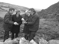 talc mine site, Sandyhill, Westport, February 1983.. - Lyons0015182.jpg  Second from the right John Bruton Minister for Industry and Energy; second from the left Enda Kenny with Tara  Mine representativel for Holden Communications at the talc mine site, Sandyhill, Westport with a local man looking at samples from the talc mine. February 1983. : 19830212 Talc Mine Site 1.tif, Lyons collection, Westport