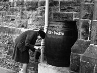 Lady getting water at Castlebar church, 1965 - Lyons0000348.jpg  Lady getting water at Castlebar church, 1965 : Castlebar, church, collection, Lady, water